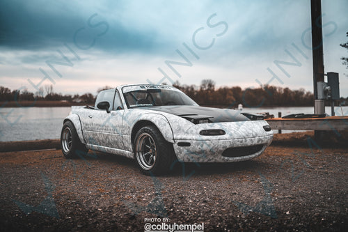 Detailed view of a Mazda MX5 NA MK1 with a fiberglass wide body kit, highlighting the added clearance on both front and rear fenders
